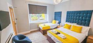 Una habitación con dos camas y un televisor de pantalla plana. en mySTAYINN Strathblane House, en Inverness