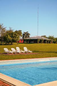 2 tumbonas y una piscina en un campo en Ibera Lodge en Mercedes