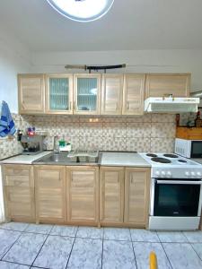 La cuisine est équipée de placards en bois et d'une cuisinière blanche. dans l'établissement Aggelina, à Sárkhos