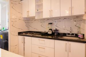 a kitchen with white cabinets and a counter top at Hermoso y Lujosso in Pitalito