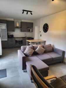 a living room with a couch and a kitchen at Duinenbank in Bredene