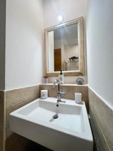 a bathroom with a white sink and a mirror at MACA HOUSE in Bari
