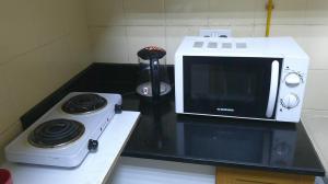 a microwave sitting on a counter next to a stove at Ruby Star Studio Apratment in Dubai