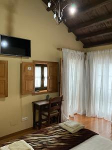 1 dormitorio con cama, mesa y ventana en Casa Milia en Castañeda