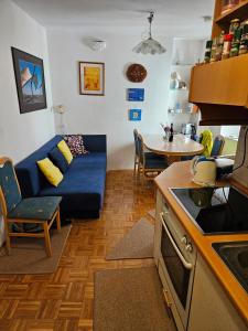 a living room with a blue couch and a table at Blue Piran in Piran