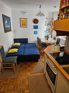 a living room with a blue couch in a kitchen at Blue Piran in Piran