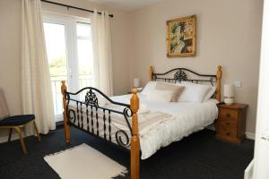 - une chambre avec un grand lit et une fenêtre dans l'établissement Greenfield Lodge Hotel Bar & Bistro, à Headford