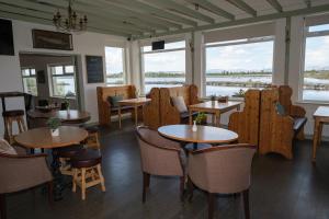 un restaurant avec des tables, des chaises et des fenêtres dans l'établissement Greenfield Lodge Hotel Bar & Bistro, à Headford