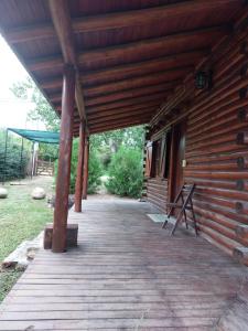 a wooden porch of a log cabin with a roof at Azul in Arroyo de Los Patos