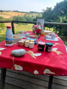 einen Tisch mit einem roten Tischtuch mit Futter drauf in der Unterkunft Le Chouette loft 