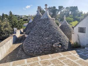 a large stone building with a roof at La magia del trullo in Martina Franca