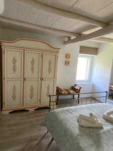 Casa Biscarello - Borgo e Lago في Grotte di Castro: غرفة نوم مع سرير وخزانة كبيرة