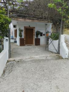Biały dom z bramą i drzwiami w obiekcie Aggelina w mieście Sárkhos