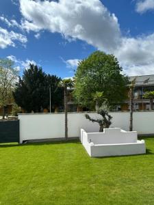 un banc blanc assis dans une cour herbeuse dans l'établissement Appartment Moltke, à Herbolzheim