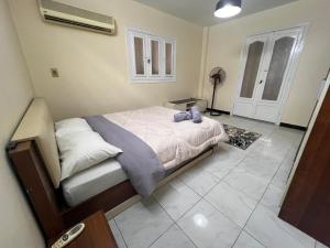een slaapkamer met een bed met een paars knuffeldier erop bij Cairo's Heart Central Apartment in Masr El Gedida in Caïro