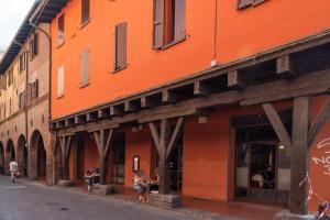 due persone sedute su panchine fuori da un edificio di NETTUNO LUXURYH - BOLOGNACENTRO Duomo Rooms and suites a Bologna Altre 6 foto
