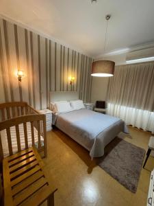 a bedroom with a bed and a chair in it at Solar S.Bento in Santo Tirso