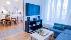un salon avec un canapé bleu et une télévision dans l'établissement La maison du bonheur Saint-Ouen, à Saint-Ouen
