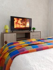 a bedroom with a bed with a flat screen tv at 12 Microragion Apartments in Aktobe