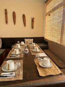 un lungo tavolo in legno con cappelli e piatti di Résidence Tianay a Antananarivo