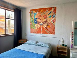a bedroom with a bed and a painting on the wall at Casa Satoshi in San Cristóbal de Las Casas