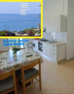 a kitchen with a table and a view of the ocean at Cialoma Full Green in Marina di Camerota