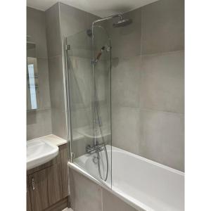 a bathroom with a shower with a tub and a sink at Spacious 1 Bedroom Flat in Kilburn Park F55 in London