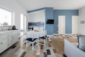 una sala da pranzo con tavolo bianco e pareti blu di Rifugio a Mare a Calabernardo