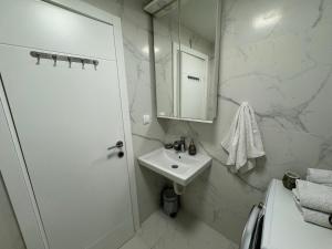 un bagno bianco con lavandino e doccia di Front Row Sunset a Rafailovici