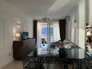 una sala da pranzo con tavolo e sedie in vetro di Front Row Sunset a Rafailovici Altre 7 foto