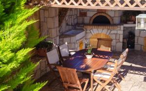 a wooden table and chairs in front of a pizza oven at Gournes Mare Luxury Villa with private pool in Gournes