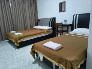 a hotel room with two beds and a table at NaVita Lodge in Tamparuli