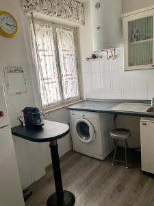 eine Küche mit einer Waschmaschine und einem Waschbecken in der Unterkunft Appartamento Lignano Sabbiadoro Centro in Lignano Sabbiadoro