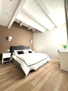 een slaapkamer met een groot wit bed en een houten vloer bij Vanessa Home in Burano