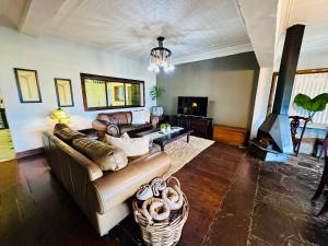 a living room with a couch and a fireplace at 49onMain Self Catering Holiday Home in Sabie