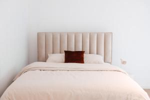 Dormitorio blanco con cama blanca grande y almohada en K-suites en Bruselas