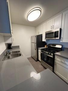 a kitchen with a sink and a refrigerator at Incredible Two Bedroom Hollywood Apartments FREE Parking in Los Angeles