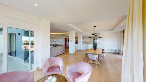 a dining room with pink chairs and a table at Atico Serenity by Oliva Nova in Oliva