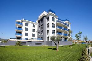 a large white apartment building with a green lawn at Atico Serenity by Oliva Nova in Oliva