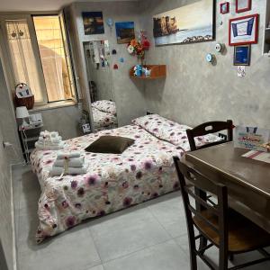 1 dormitorio con cama con edredón y mesa en Casa Sofia, en Nápoles