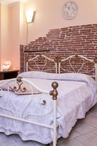 a white bed in a room with a brick wall at Il Giardino di Laura in Corsanico-Bargecchia