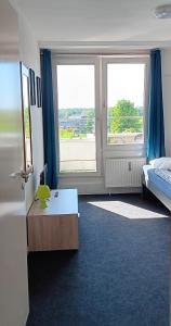 a room with a bed and a desk and two windows at Zimmer zentral in Berlin in Berlin