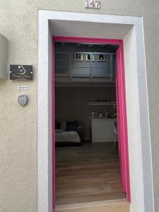 a pink door leading into a room with a bedroom at Vanessa Home in Burano