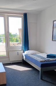 a bedroom with a bed and a large window at Zimmer zentral in Berlin in Berlin