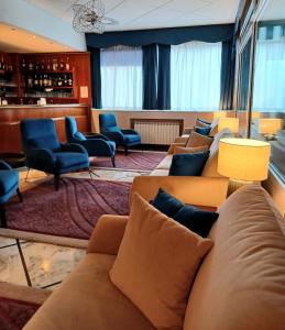 a waiting room with couches and chairs and a bar at Hotel Ariston in Imperia