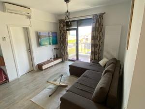 ein Wohnzimmer mit einem Sofa und einem TV in der Unterkunft Black Sea Apartment in Mamaia Nord – Năvodari