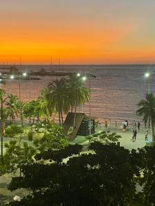 una playa con palmeras y el océano al atardecer en HOTEL MAR Y MAR, en Santa Marta