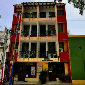 un edificio rojo con balcones en un lateral en HOTEL MAR Y MAR, en Santa Marta