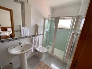 a bathroom with a sink and a shower and a toilet at Solar S.Bento in Santo Tirso