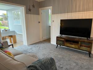 a living room with a large flat screen tv at Ocean Cottage, Ferring - seaside cottage moments from the beach and Bluebird cafe in Ferring